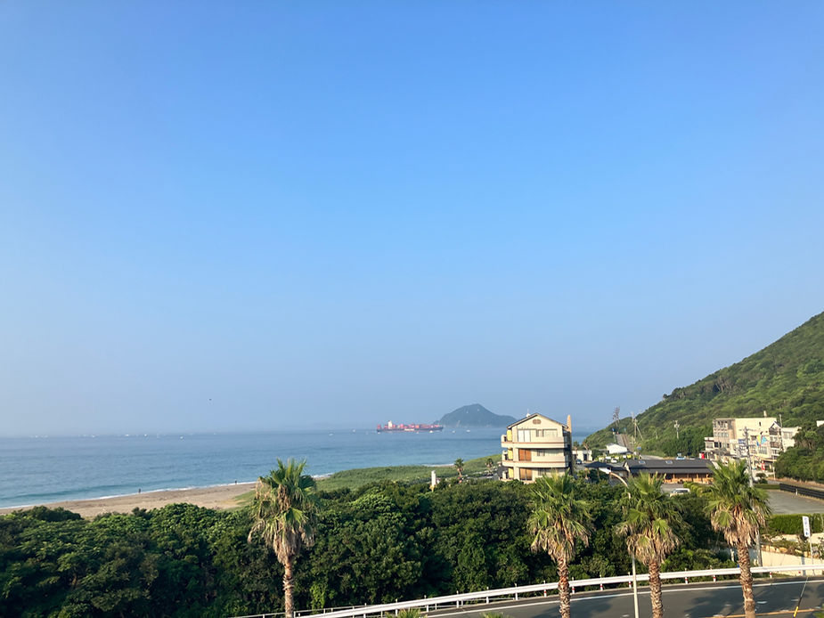 屋上から海と山、恋路ヶ浜が見える風景