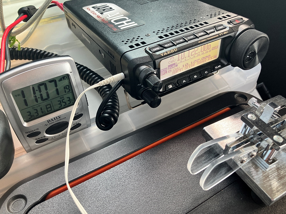 無線機、パドル、35℃を示す温度計付きの時計がある車内の写真